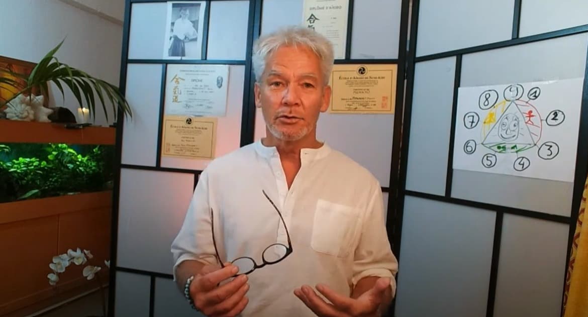 Pierre Pyronnet devant ses diplômes Aïkido et le schéma des 9 étapes